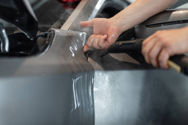 istock professional man will cover a car with protective PPF film at a detailing service. 2201640775