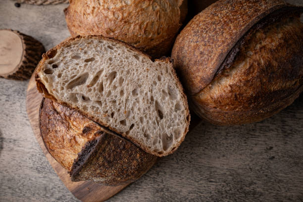 istock Golden-Crusted Artisan Sourdough Bread on a Rustic Wooden Table. 2201644648