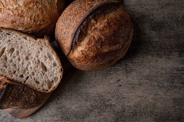 istock Golden-Crusted Artisan Sourdough Bread on a Rustic Wooden Table. 2201644651