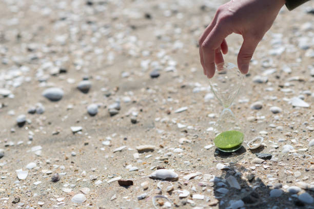 Person holding an hourglass on the beach