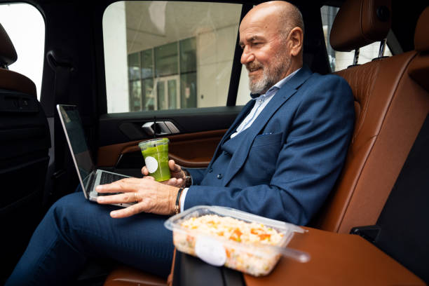istock Senior businessman working from car 2201653523