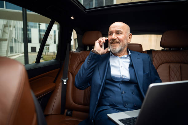 istock Senior businessman talking on smart phone while sitting in the car 2201653651