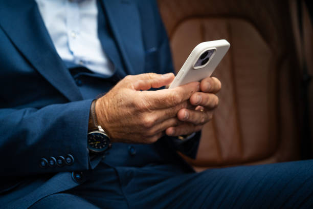 istock Senior businessman using smartphone in car 2201653684