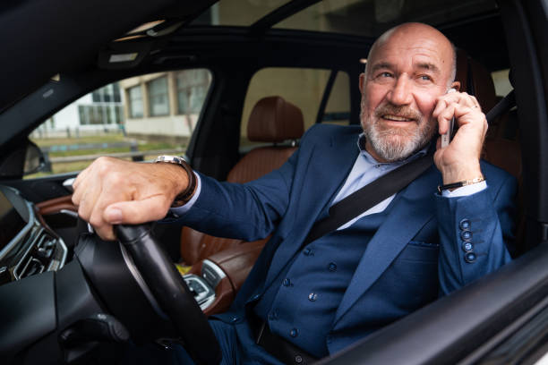 istock Senior businessman discussing business details while driving car 2201653775