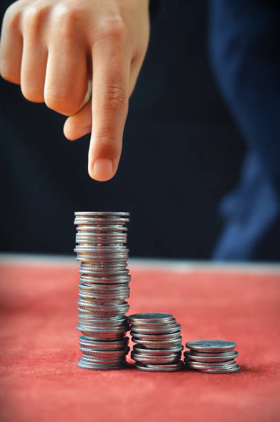 Vertical click a finger pointing, targeting the highest or tallest of three tower or stack of Indian currency coins arranged in ascending order signifying business targets, income,  growth with  copy space. Can be used for return on investments, business growth, wage gap related pictures,