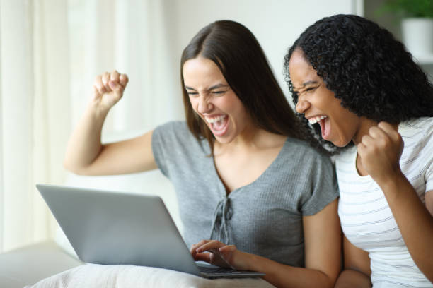 istock Excited interracial roommates checking laptop and celebrating 2201666635