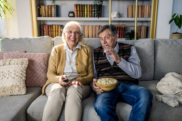 istock Senior Caucasian Couple Relaxing on Sofa Watching TV Together 2201674793