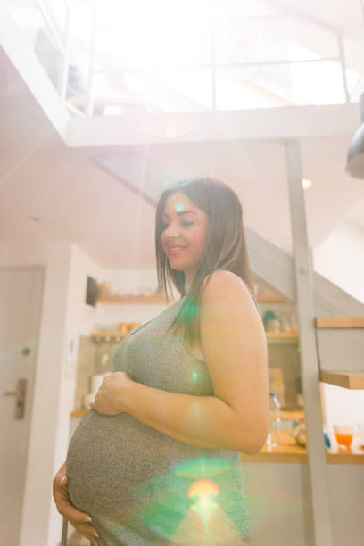 pregnant woman on the phone in the kitchen