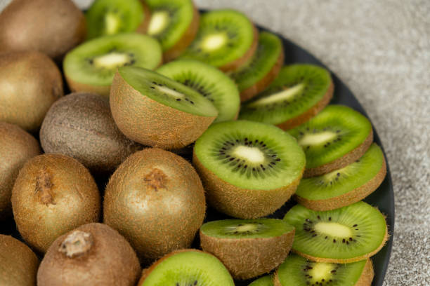 istock Plate of sliced and whole fresh kiwi fruit. 2201676196