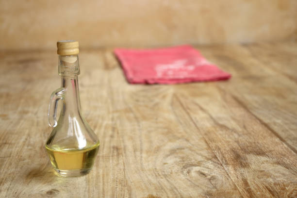 small cruet of olive oil on a wooden surface with a colored cloth
