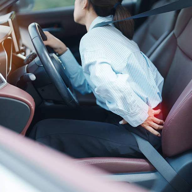 istock woman with her back sprain while driving car long time, back body ache due to Piriformis Syndrome, Low Back Pain and Spinal Compression. Ergonomic and medical concept 2201678008