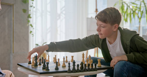 istock Caucasian Boy Engaged in Chess Game 2201682316