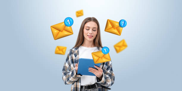istock Young woman checking tablet surrounded by floating email icons o 2201683574