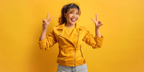 istock Cool asian woman in a yellow jacket and sunglasses 2201687407