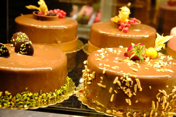 Chocolate cakes in a pastry shop window. Strawberry, pistachio, croquant cakes. Birthday cake. Pastry art. Pastry products. Food industry.