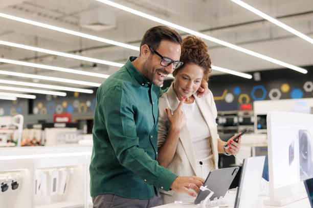 istock Smiling couple shopping for electronics in a modern appliance store 2201688483