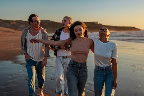 istock Friends walking on beach at sunset, enjoying summer vacation 2201688943