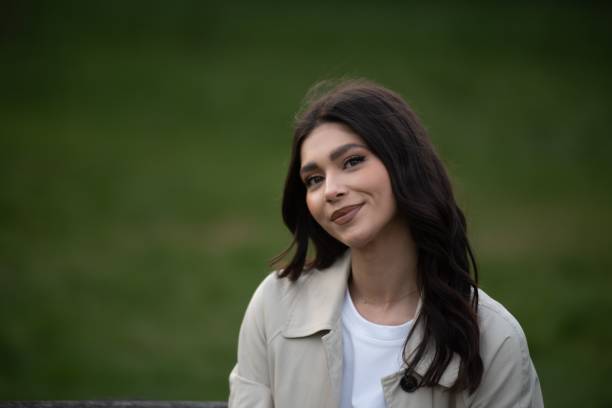 istock Young woman smiling with a green backdrop. 2201689831