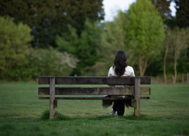 istock Woman on Bench in Green Park 2201689889