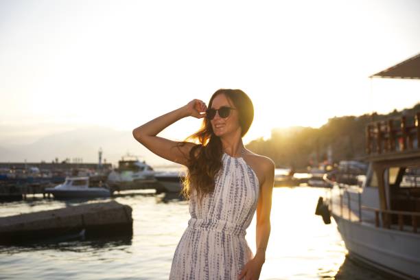 istock Smiling woman enjoying sunset at marina 2201689896