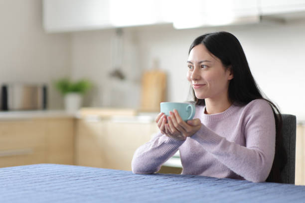 istock Relaxed asian woman drinking and contemplating 2201690870