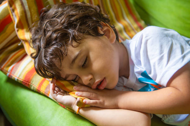Four-year-old boy taking an afternoon nap after lunch.