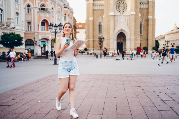 istock young woman using mobile phone while walking through the city 2201695472