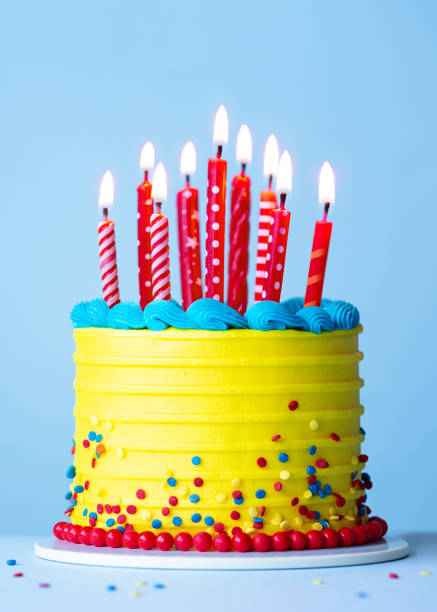 istock Brightly colored celebration birthday cake with red candles 2201697480