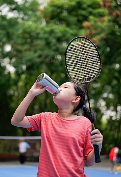 istock Little girl play badminton, resting and drinking water 2201699391