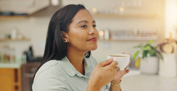 istock Woman, thinking and cup of tea in home, peaceful reflection and morning routine for perspective. Female person, hot beverage and relax in kitchen for nostalgia, comfort memory and contemplating 2201699741