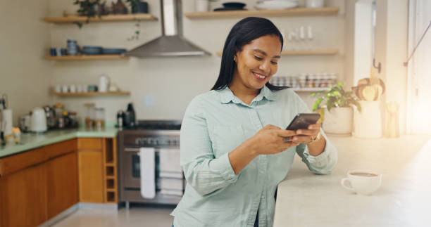 istock House, smile and woman with smartphone, typing and internet with connection, network and coffee. Happy person, mobile app and girl in kitchen, cellphone and communication with social media or message 2201699752