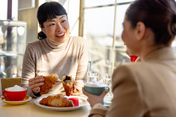 istock Japanese woman enjoying with friend on breakfast in caffe 2201700587