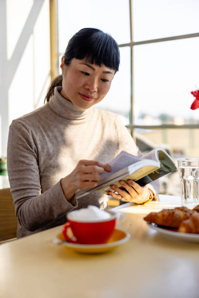 istock Japanese woman in caffe drink coffee and read a book 2201700627