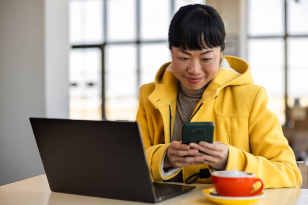 istock Japanese woman drinking coffee and using laptop 2201700830