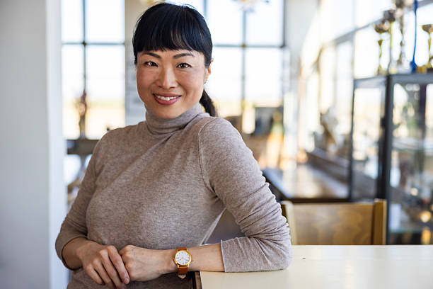 istock Asian woman in caffe looking at camera 2201700920