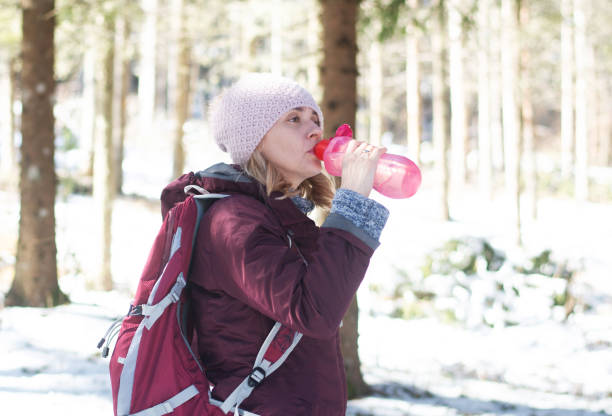 istock Thirsty woman hiker drinking water with plastic bottle 2201701174