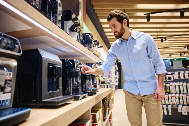 istock A man shops for various kitchen appliances, closely examining coffee makers in a modern store 2201703922