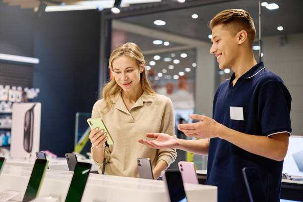 istock Customer and Salesperson Actively Engaged in the Smartphone Selection Process at Retail Store 2201703931