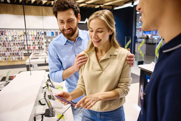 istock Exploring the shopping experience in a modern electronics store with customers and a salesperson 2201703960