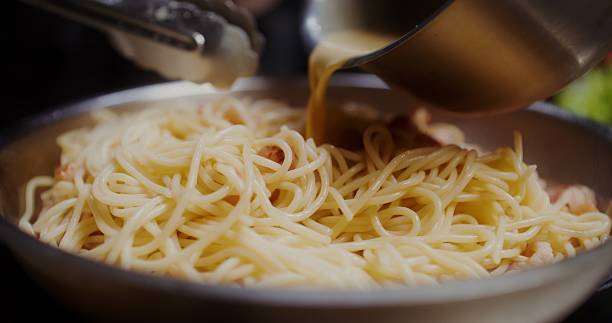 istock Pasta with bacon fried in a frying pan 2201706116
