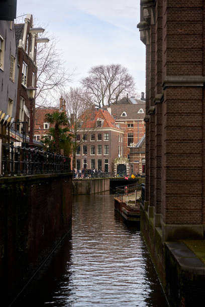 istock Canal flowing between buildings in amsterdam, netherlands during cloudy day 2201707597