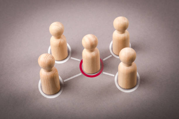 istock Wooden figures on a gray background. Intermediary between groups Political negotiations 2201712922