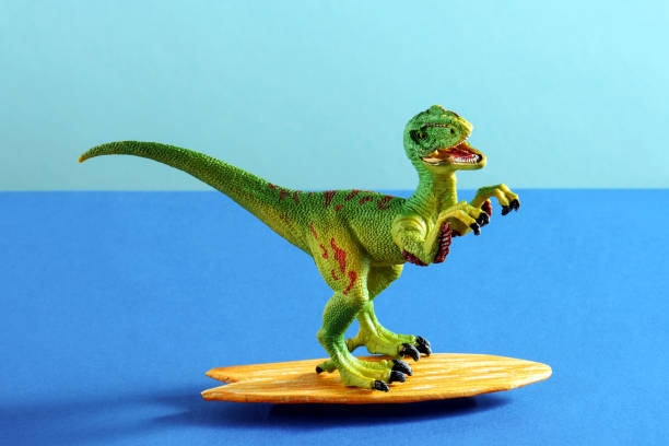 istock Happy dinosaur with surfboard on blue background. 2201713386