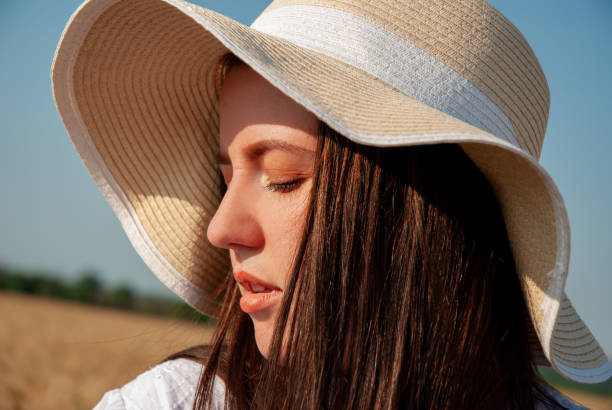 istock Serenity in nature: woman with sun hat in countryside setting. Harvesting concept 2201715293
