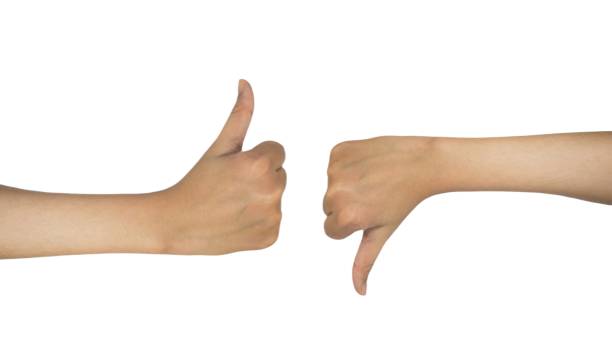 istock Two female hands giving thumbs up and down on white background, business concept. 2201715357