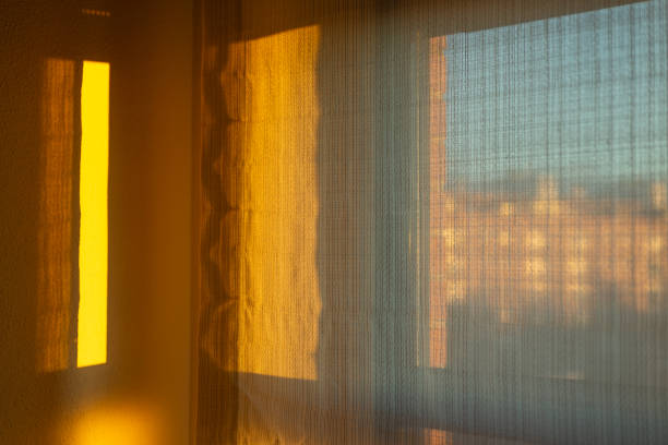 Vitoria-Gasteiz, Spanish Basque Country. Warm sunlight filtering through sheer curtains casts a soft, golden glow across a cozy room, creating an inviting and peaceful atmosphere perfect for relaxation and comfort