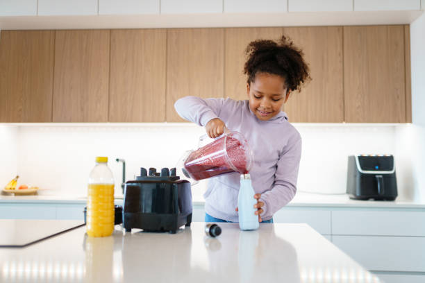 istock Confident Girl Pouring Smoothie in Bright Kitchen 2201715688