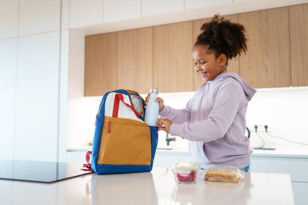 istock Mixed Race Girl Packing Lunch in Modern Kitchen 2201715726