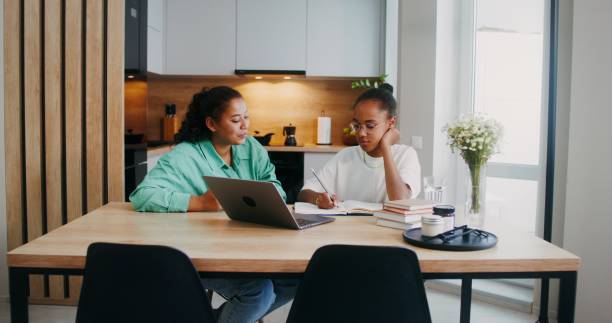istock Mom helps her daughter do her homework 2201717030