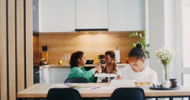 istock Mom feeds the baby in the kitchen 2201717863